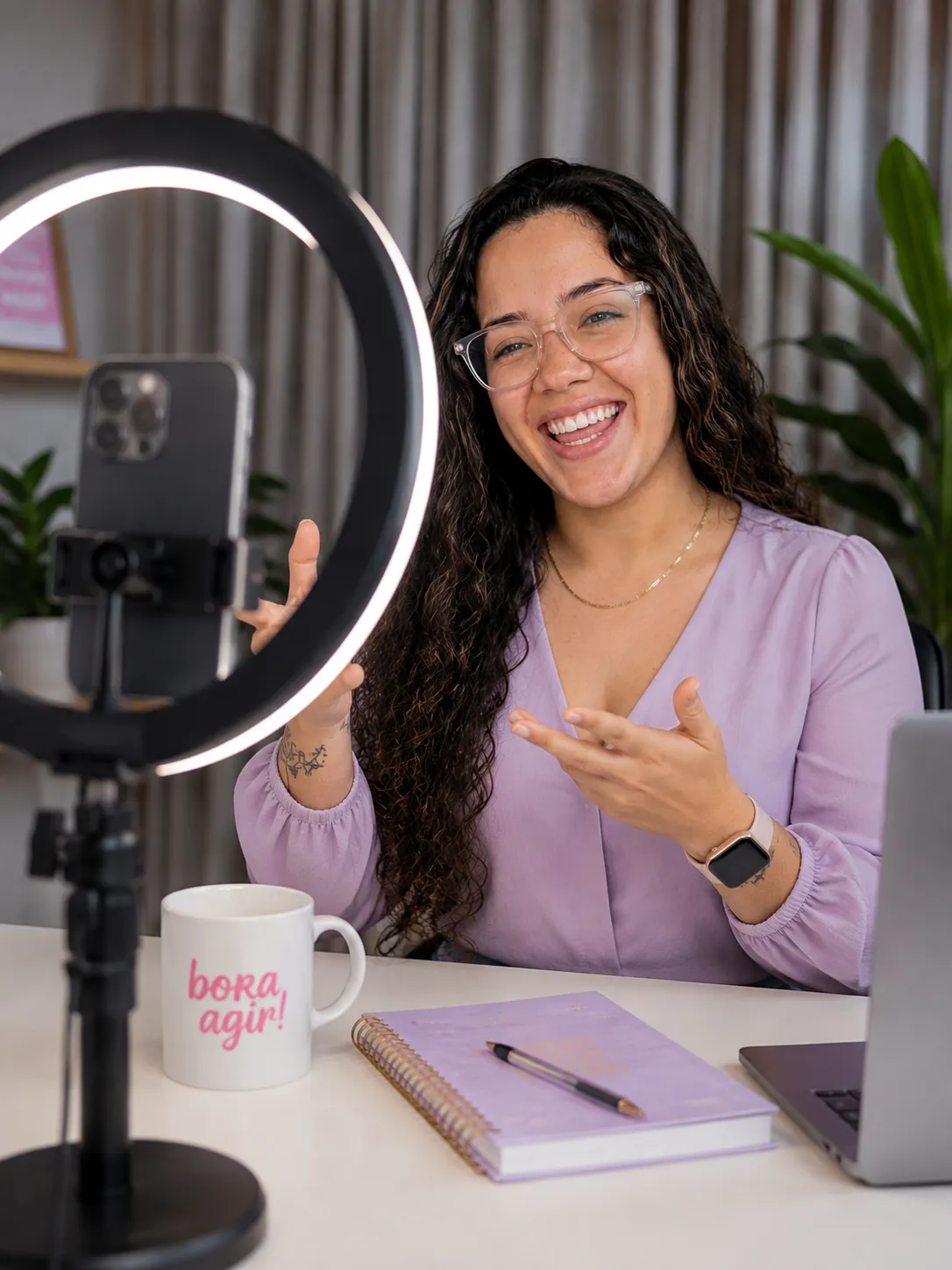 Creadora de contenido grabándose con su móvil y un aro de luz